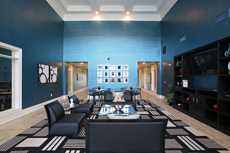 Community area with a large television and black leather couches
