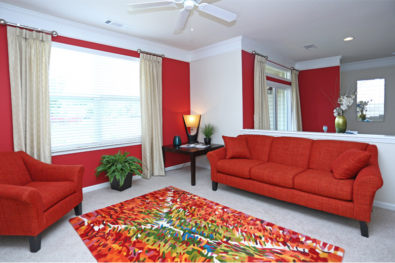 Furnished living room with red decor