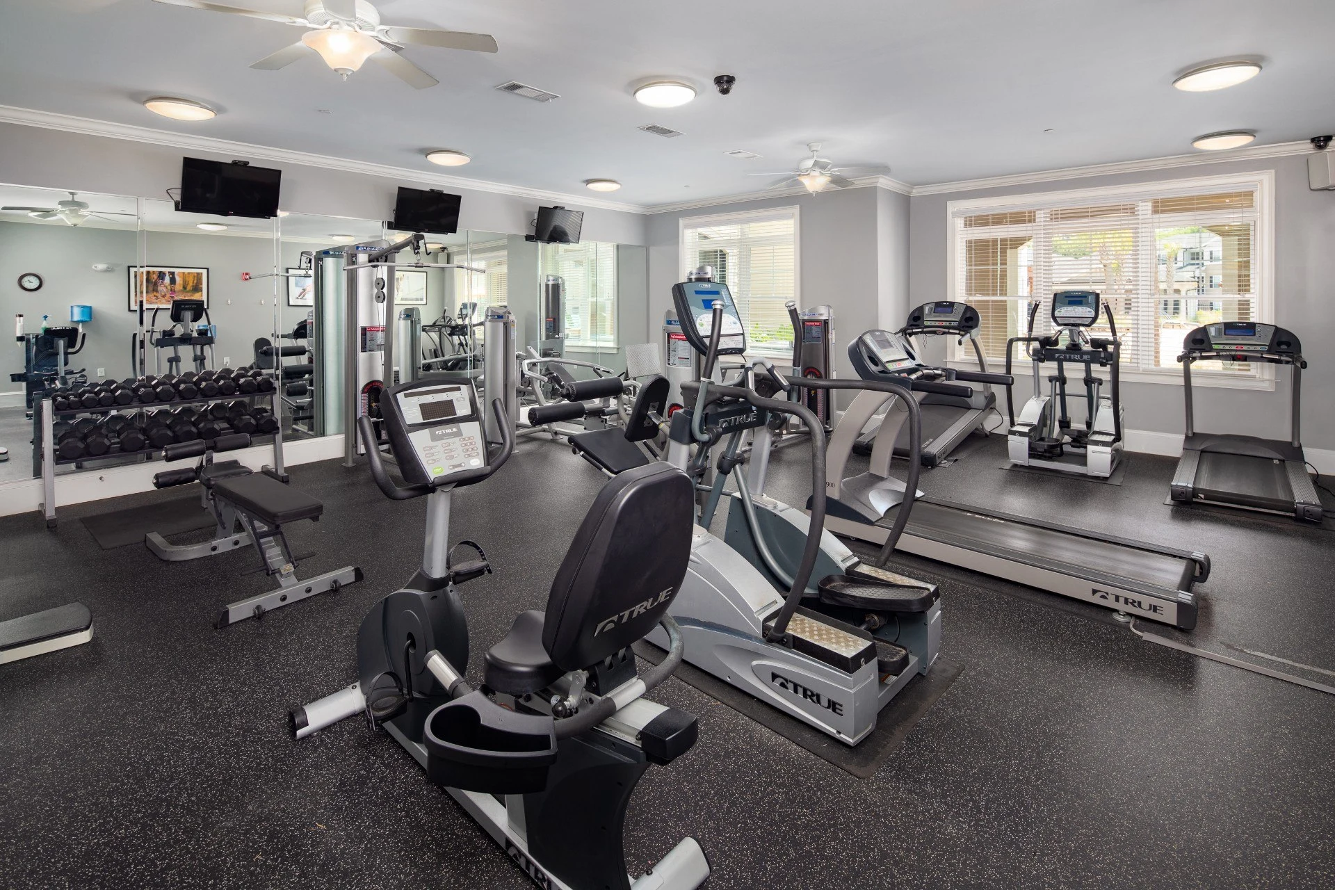 Fitness center with wall length mirror, cardio and weight lifting equipment