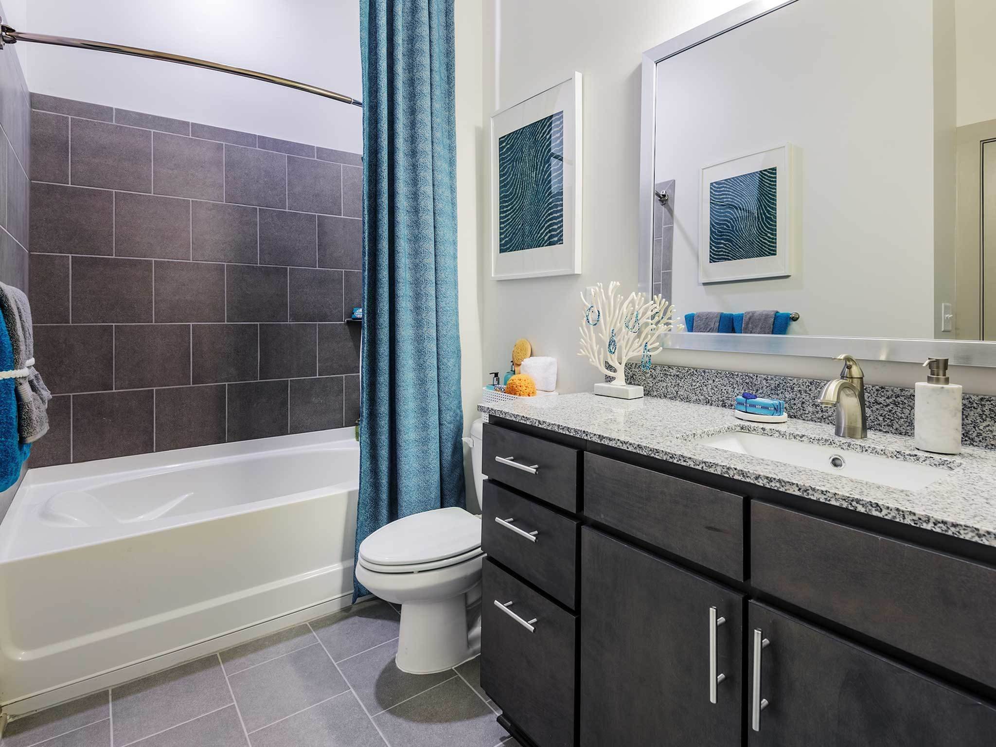 Renovated bathroom with granite countertops and blue accents.
